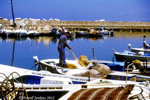 A fisherman works with his nets in the small harbor of Tyre. Photo by Ferrell Jenkins.