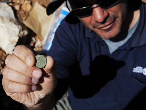 Pablo Betzer, IAA District Archaeologist for Judah, with a coin from Year Four of the Great Revolt. Photo Vladimir Nühin, IAA.