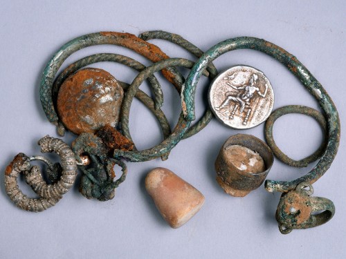 A general picture of the cache of silver objects: two coins of Alexander of Macedon, three rings, four bracelets, two decorated earrings, three other earrings (probably made of silver) and a small stone weight. Photographic credit: Clara Amit, courtesy of the Israel Antiquities Authority.