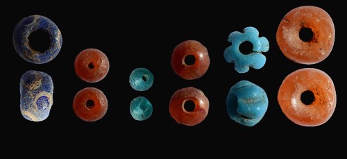 Colored beads that were uncovered in the archaeological excavation inside the dolmen. Credit: Shmuel Magal, courtesy of the Israel Antiquities Authority.