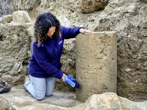 Danit Levy, Director of the excavations on behalf of the Israel Antiquities Authority, beside the inscription as found in the field. Photo: Yoli Shwartz, IAA